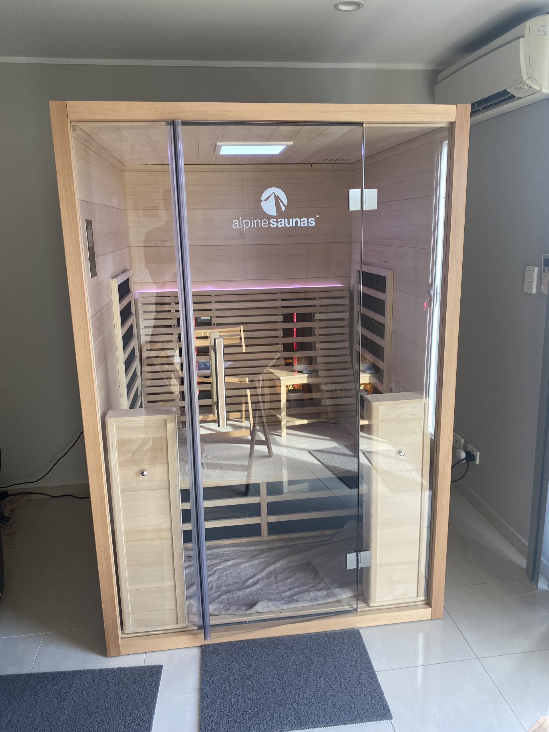 A modern wooden infrared sauna cabin with glass doors, inspired by TCM wellness principles.