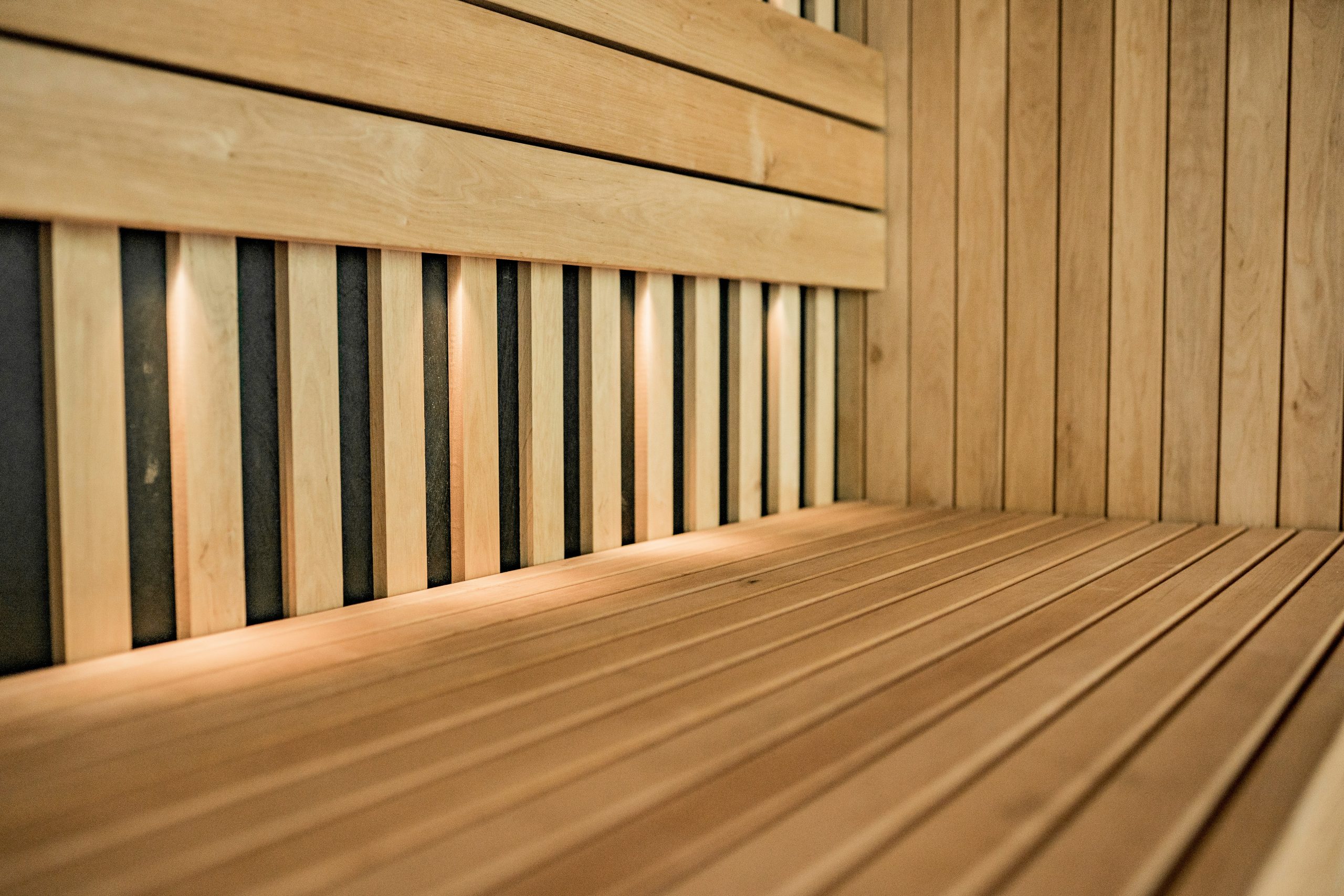 Close-up of wooden benches in a modern sauna, inspired by TCM and Chinese herbal medicine.
