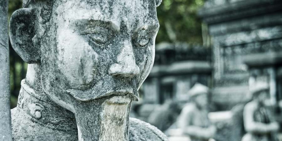 Close-up of a weathered stone statue, evoking the wisdom of ancient TCM practitioners.