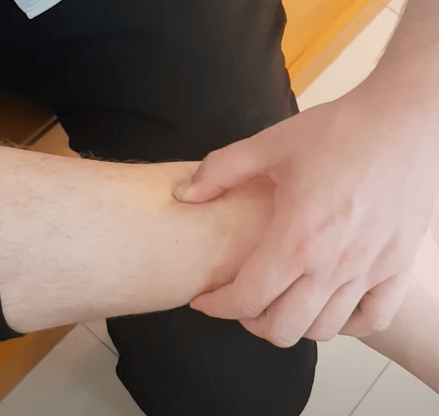 Person performing TCM pulse diagnosis or preparing for acupuncture on the wrist.