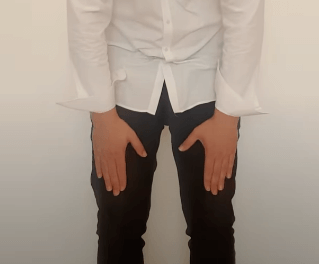 Person in a white shirt and black pants bending forward, as in a TCM posture.