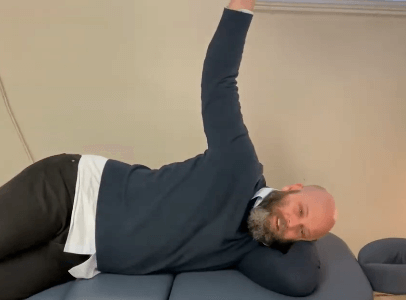 Man lying on his side, as if relaxing after an acupuncture or TCM session on a couch.